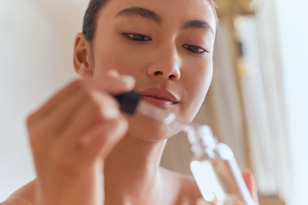 Woman using antioxidant skincare product