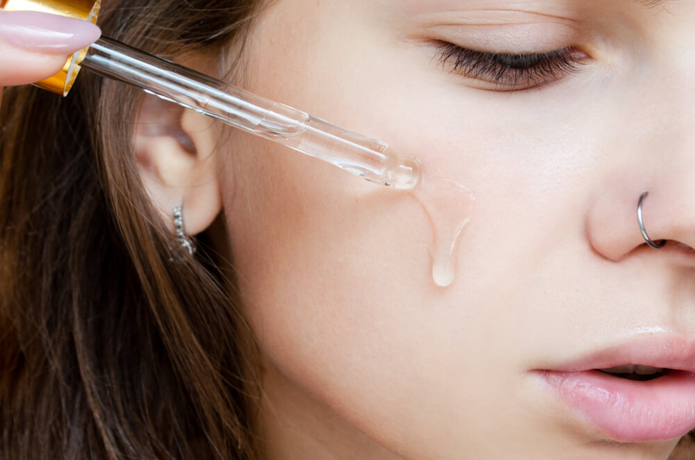 Woman applying face serum