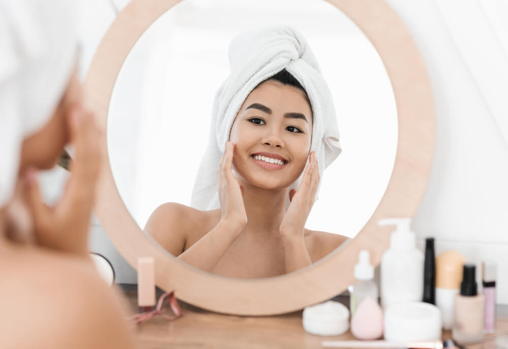 Woman looking at skin in mirror