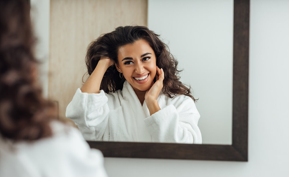 Woman looking at skin in mirror