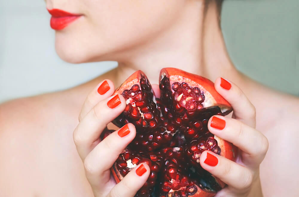 Unknown woman with a halved pomegranate