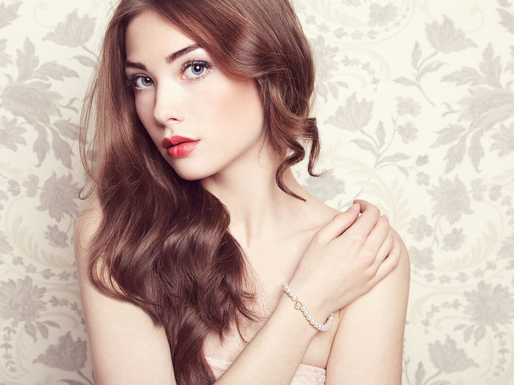 Pretty young woman in front of flower wallpaper