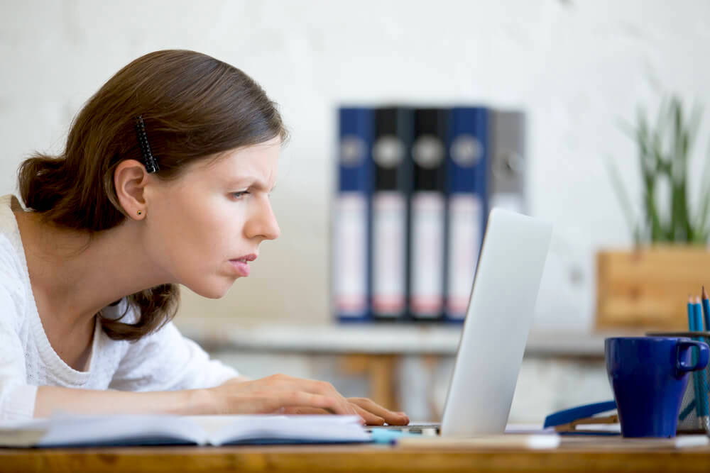 Woman squinting in front of laptop 