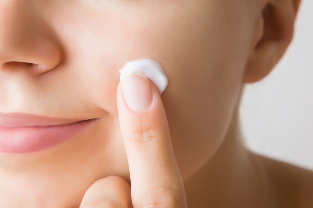 Woman applying face cream