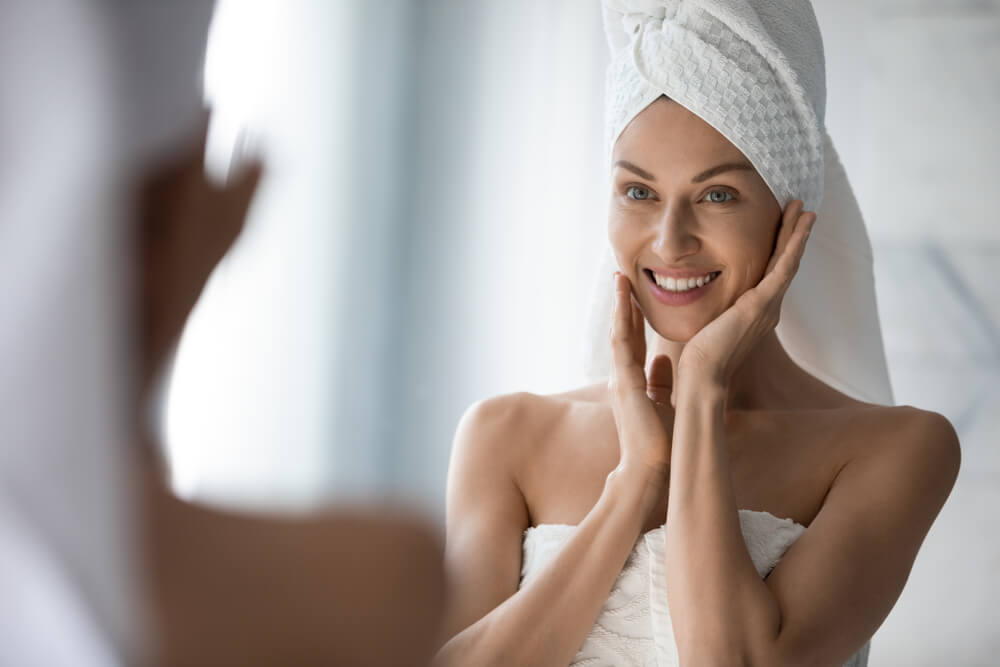 Woman looking at skin in mirror