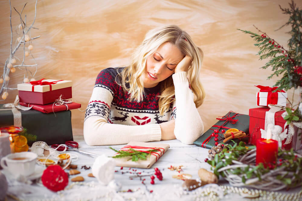 Stressed woman gift-wrapping for the holidays