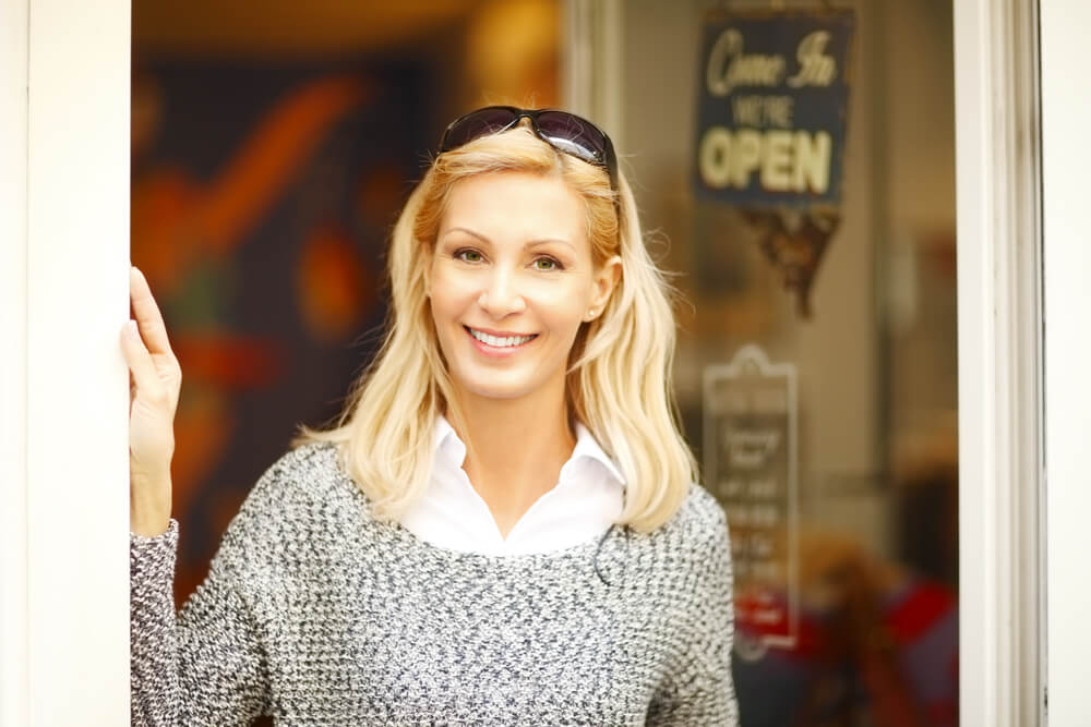 Smiling middle-age blonde woman outside a cafe