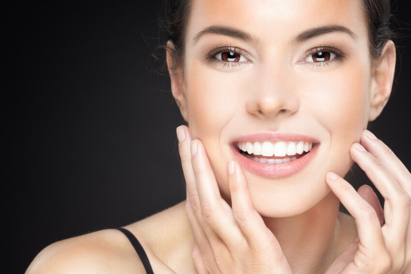Happy smiling woman touching face