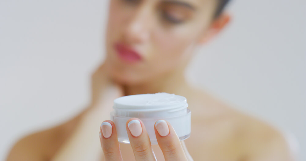 woman holding skin cream