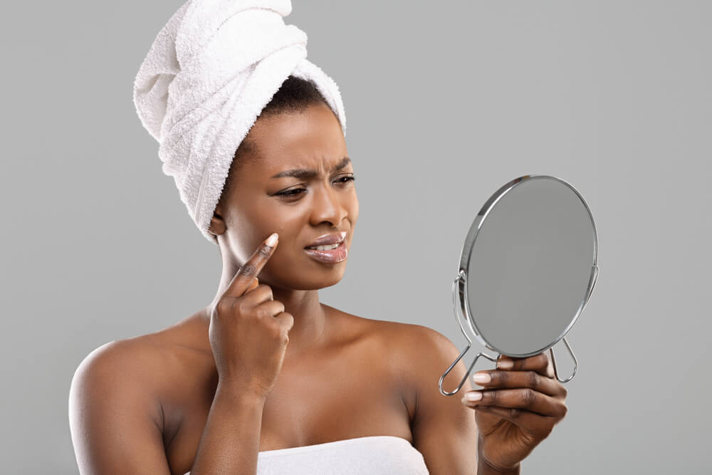 Woman looking at skin in mirror