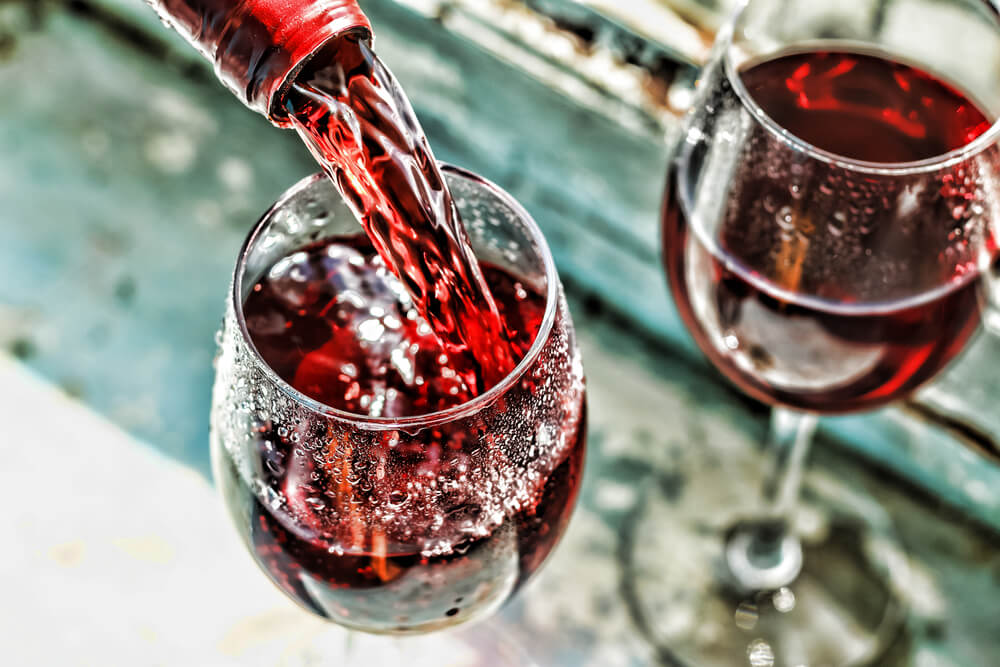 Pouring red wine into two wine glasses