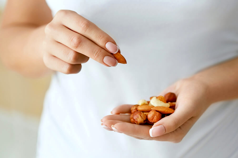 Unknown woman picking out nuts from her hand