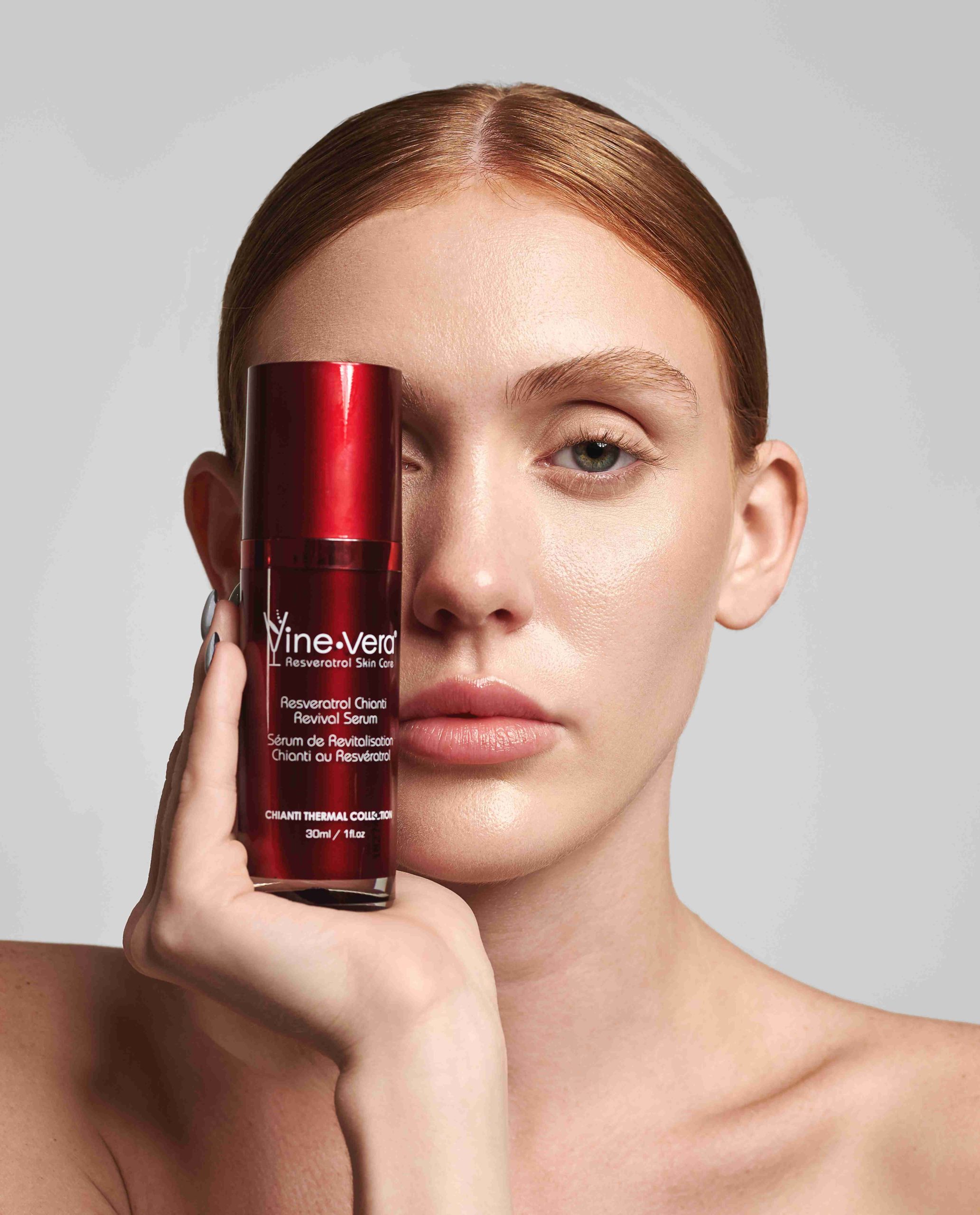 Woman holding up Vine Vera Resveratrol Chianti Revival Serum