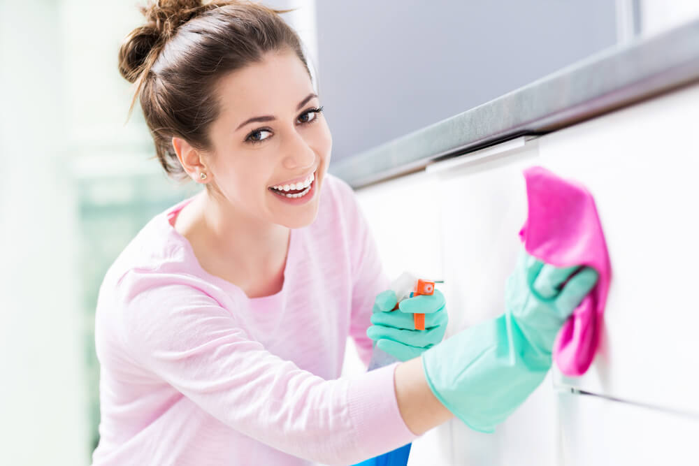 Young woman spring cleaning in the kitchen