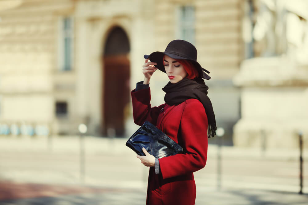 Fashionable woman in coat, scarf and hat outdoors