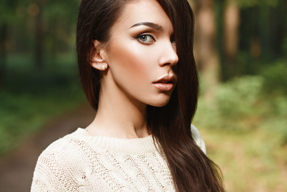 Beautiful young woman with long dark hair in the park