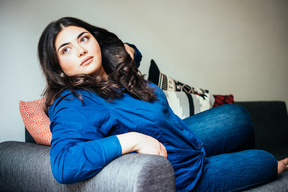 Young woman in blue sitting on the sofa