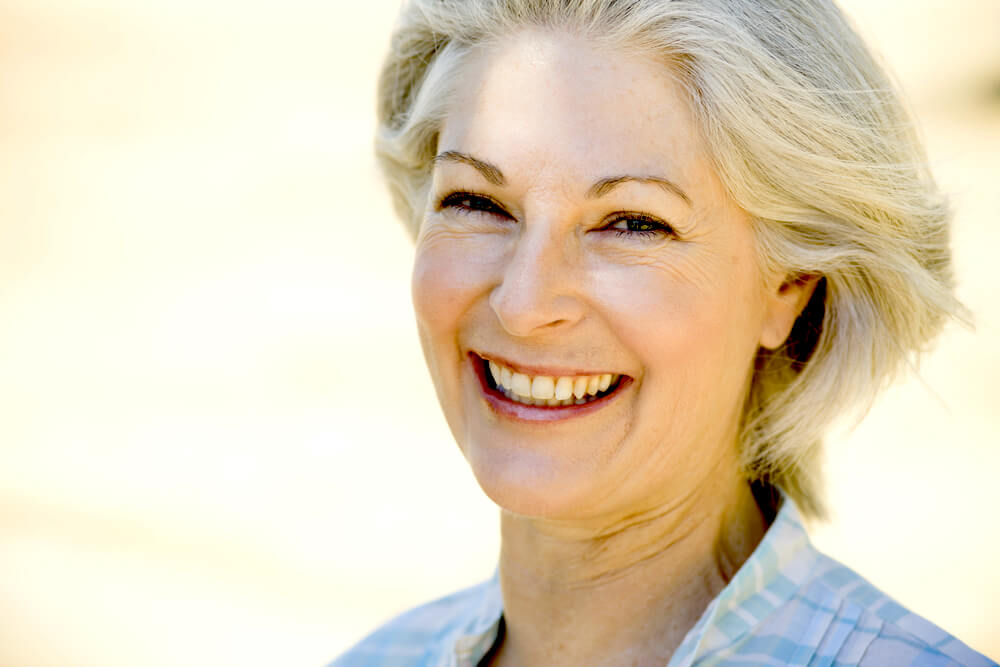 Happy smiling woman in her 50s or 60s with white hair