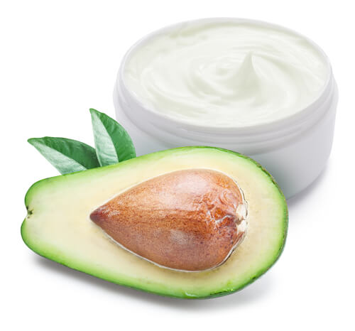 Halved avocado with a jar of moisturizer