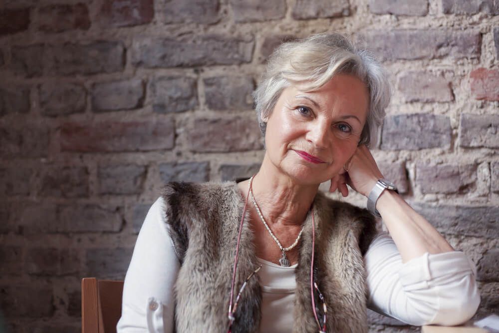 Senior woman with white hair relaxing on a chair