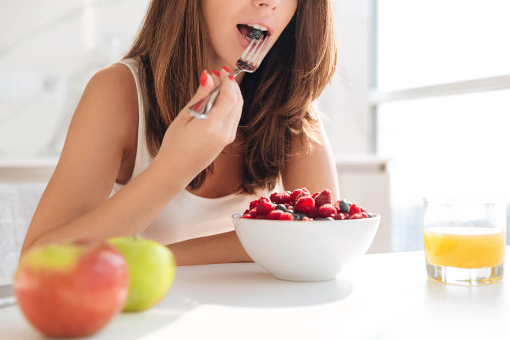 Young woman eating a bowl of berries