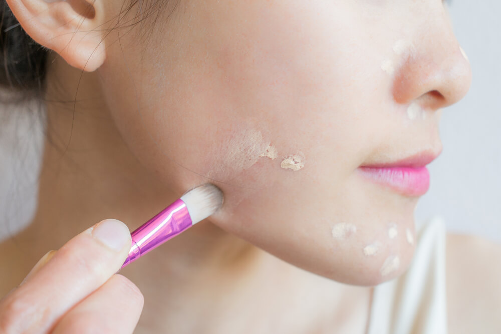 Woman applying concealer