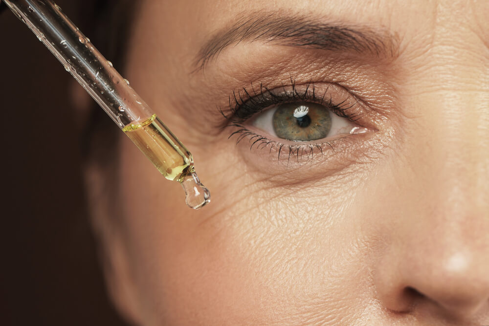 Woman applying eye serum