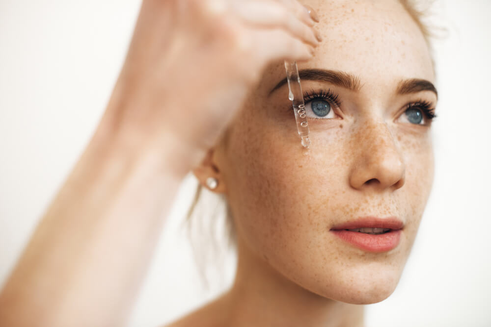 Woman applying eye serum