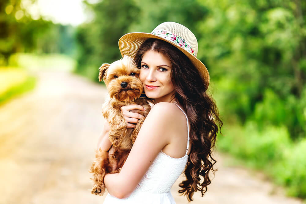 Young woman cuddling her dog outdoors