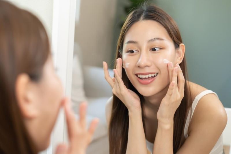 woman applying moisturizer